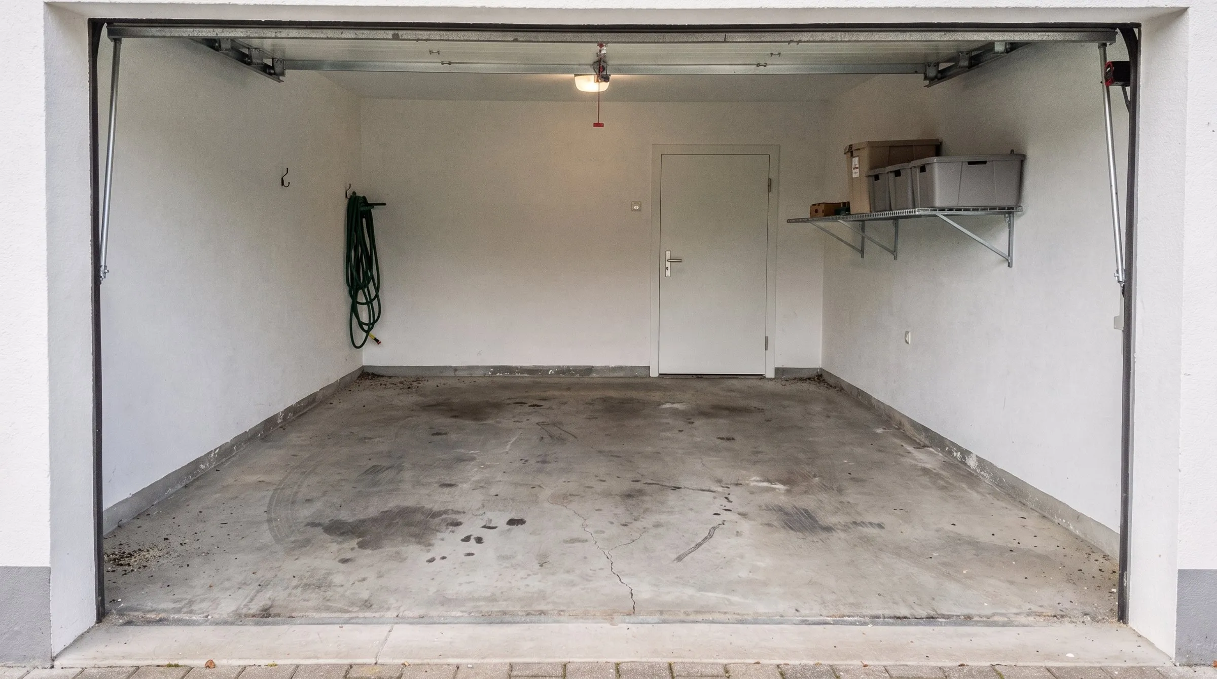 Garage vorher: roher Beton mit Ölflecken und Rissen