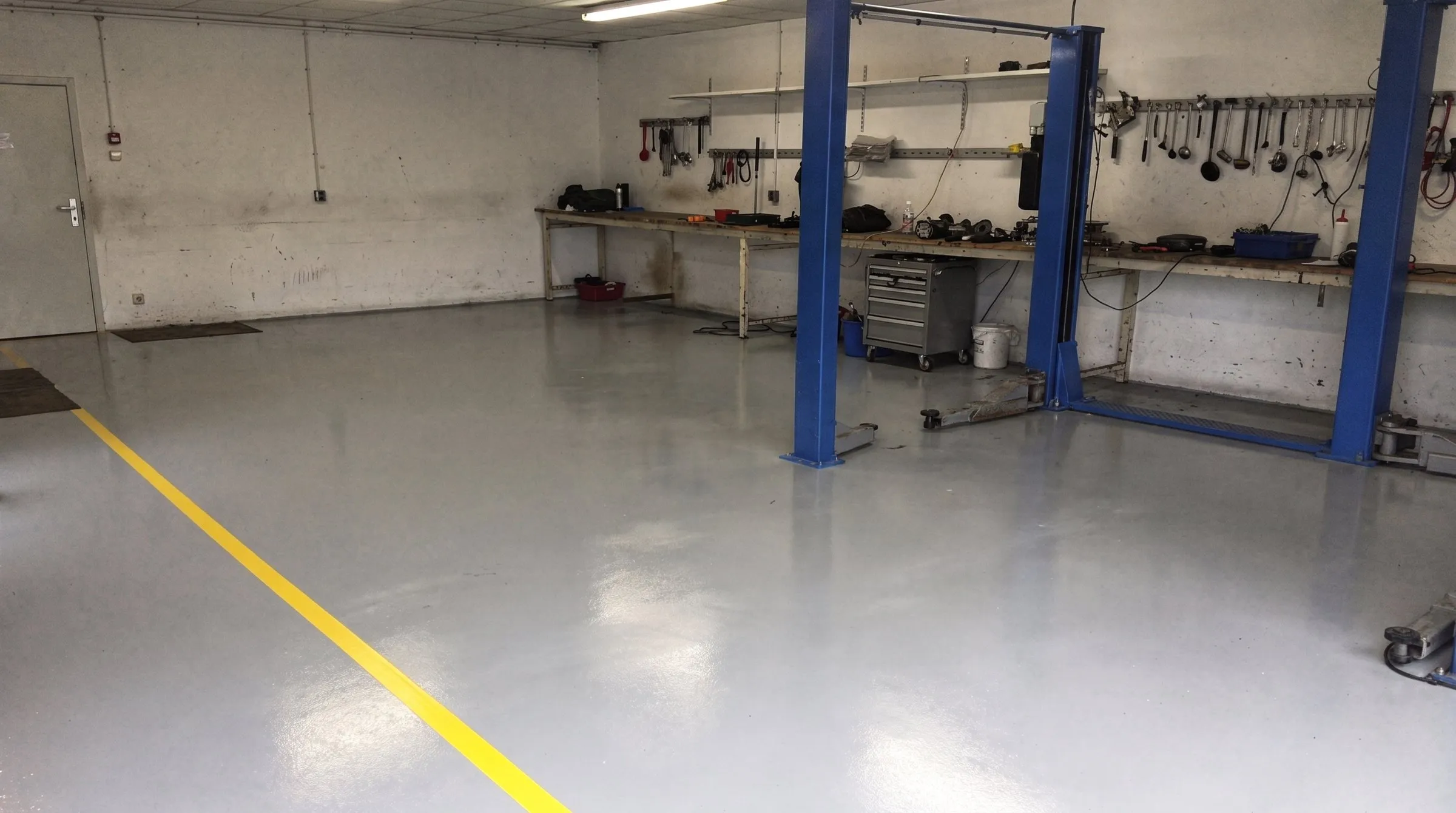 Kfz-Werkstatt mit grauem Epoxidboden und gelber Markierung